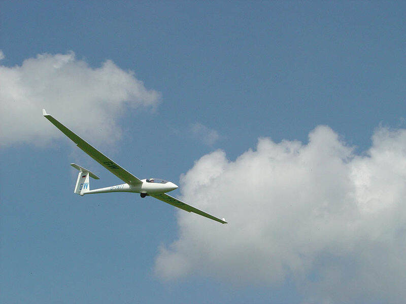 Ein Segelflieger vor blauem leicht bewölktem Himmel
