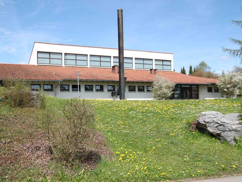 Bild der Denauhalle auf dem Hügel, mit rotem Dach und Fenstern