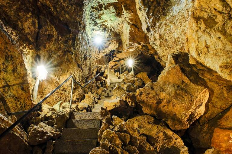 In einer Höhle führen in den stein gemeißelte Treppen steil vorbei an Felsen und der weg windet sich darauf hindurch