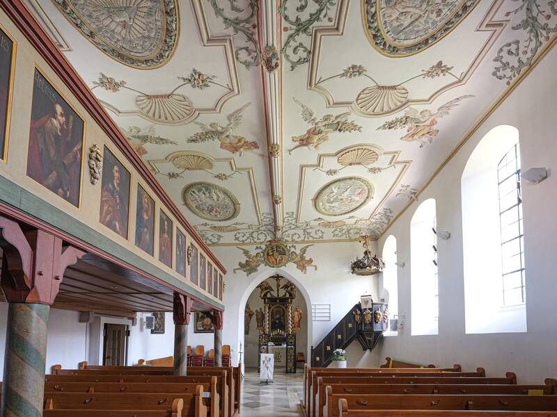 Bild der Innenseite der Liebfrauenkirche in Machtolsheim mit Bildern und Verzierungen an der Decke und Abbildern entlang der trübune
